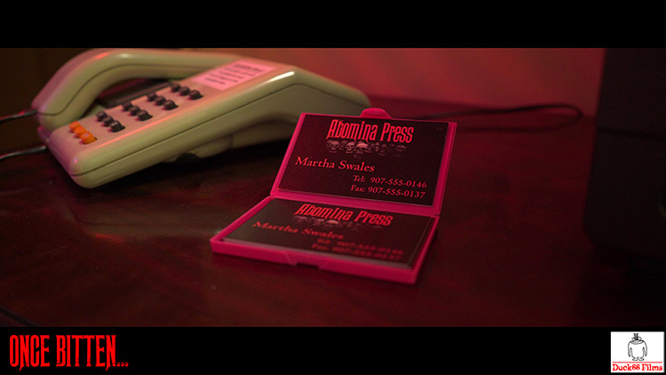 Still frame from Once Bitten... showing Martha Swales' business cards